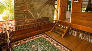 A room with a wooden bench, a patterned rug, and a wooden door.