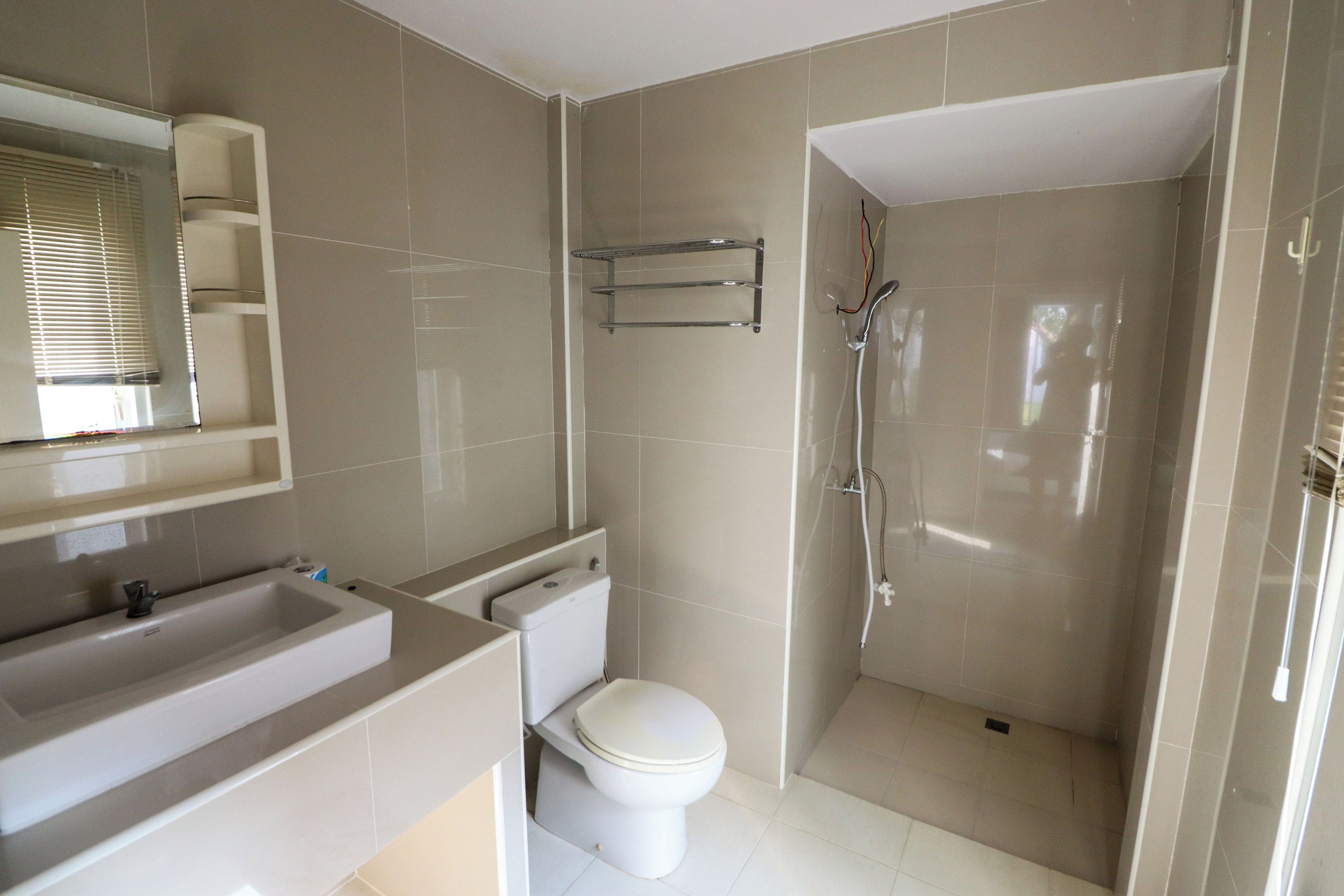 Un baño con inodoro, lavamanos y ducha.