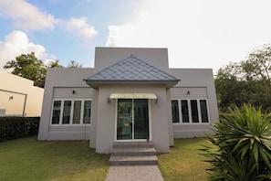 A modern building with a flat roof, a covered entrance, and a number '5' on the side. - Seamount Ban Krut (Thong Chai)