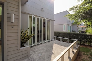 A residential building with a covered patio, a number '2' sign, and a hedge. - Seamount Ban Krut (Thong Chai)