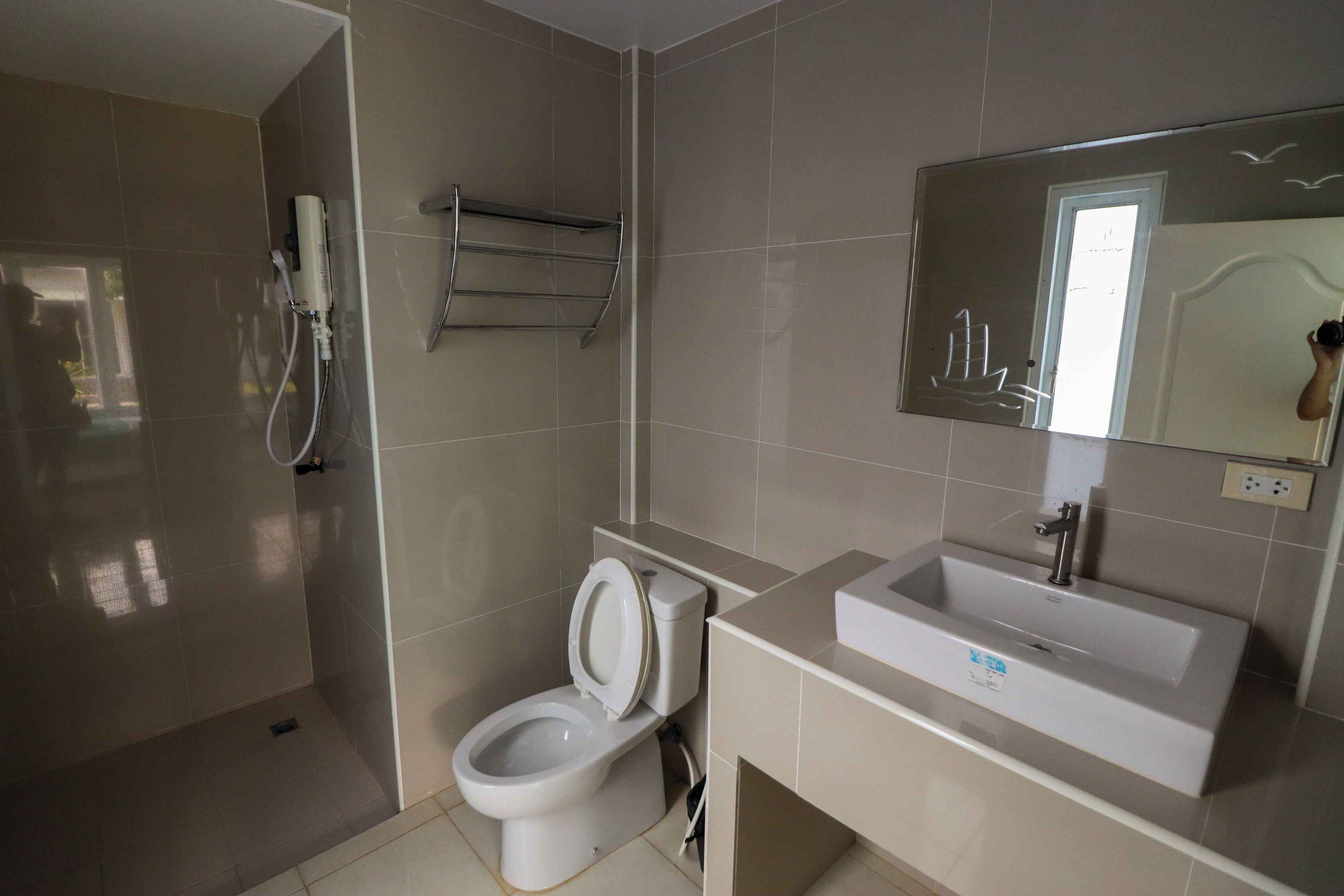 A modern bathroom with a toilet, sink, and a mirror.