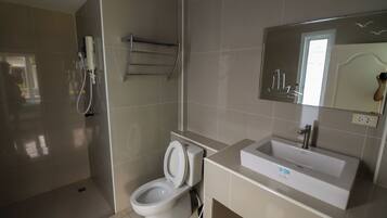 A modern bathroom with a toilet, sink, and a mirror.