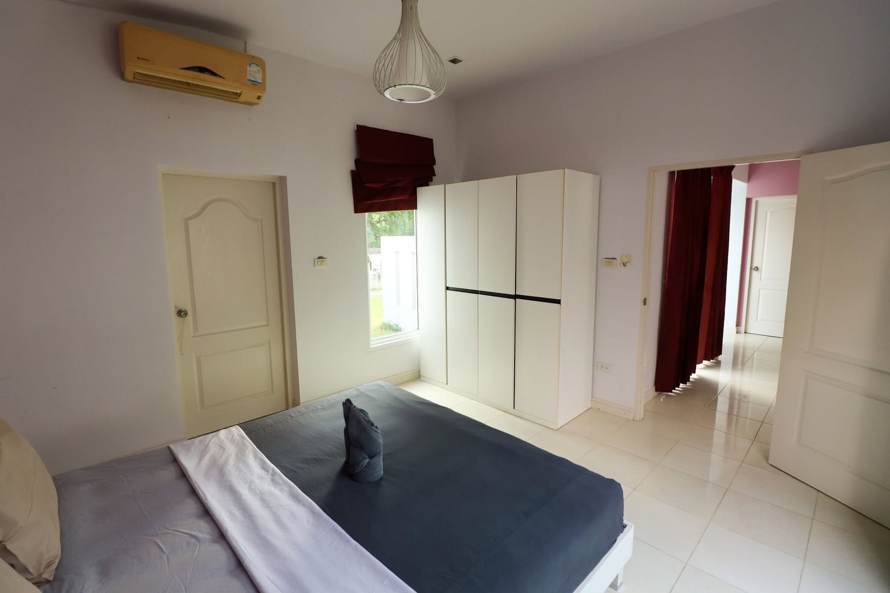 Un dormitorio con cama, armario y equipo de aire acondicionado.