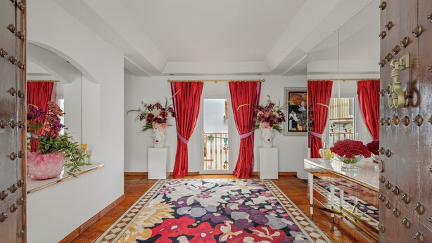 A hallway with a patterned carpet, red curtains, and floral arrangements. - Luxury villa in Marbella (Marbella)