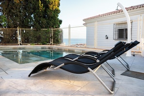 A poolside area with lounge chairs and a tiled deck.