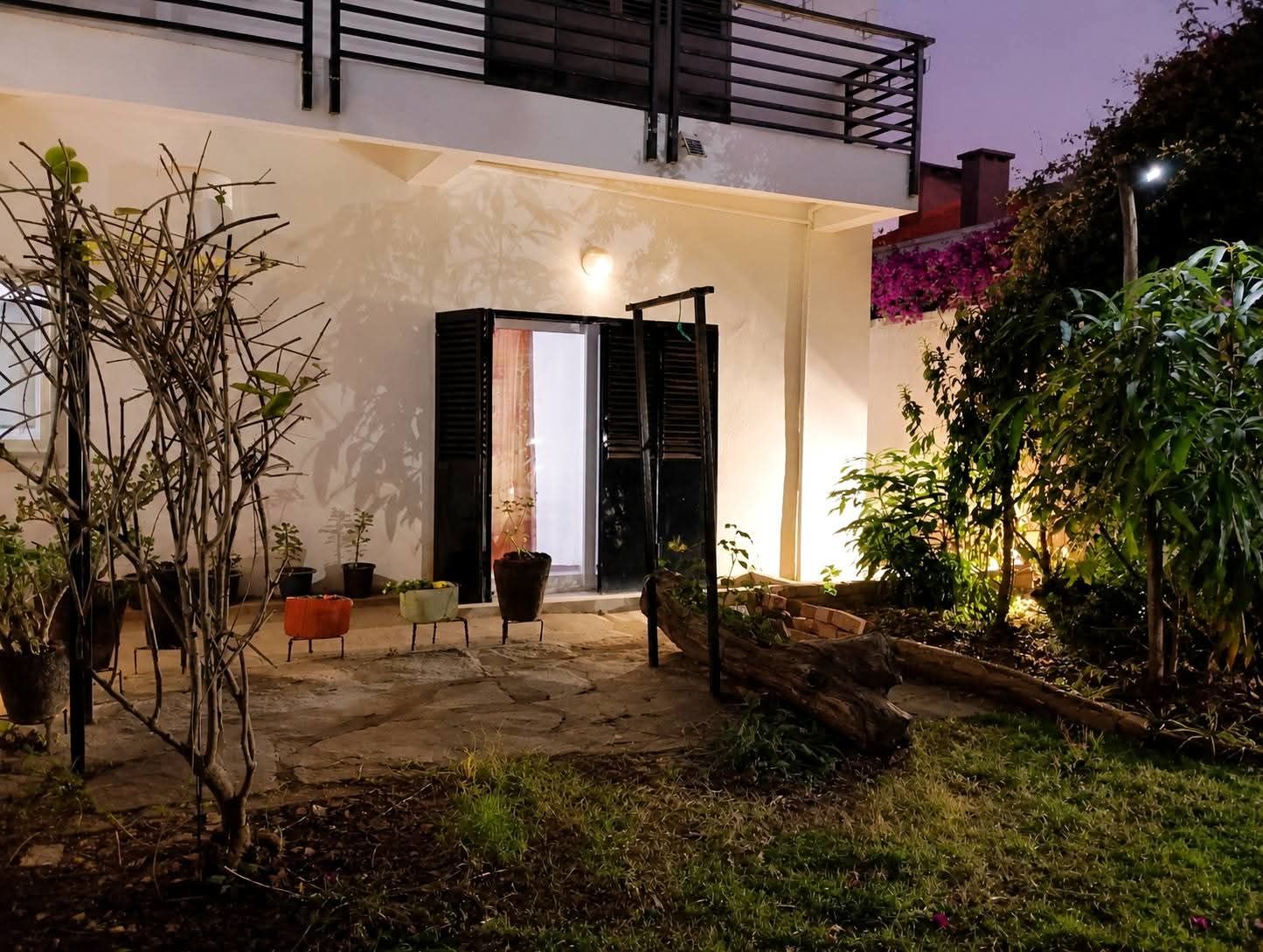 Une maison moderne dotée d’un patio, de meubles d’extérieur et de plantes en pot.