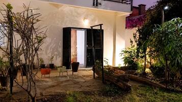 A modern house with a patio area, outdoor furniture, and potted plants.