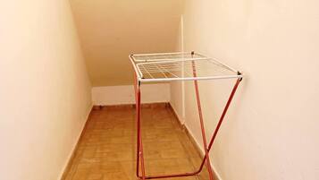 A narrow hallway with a metal drying rack mounted on the wall.