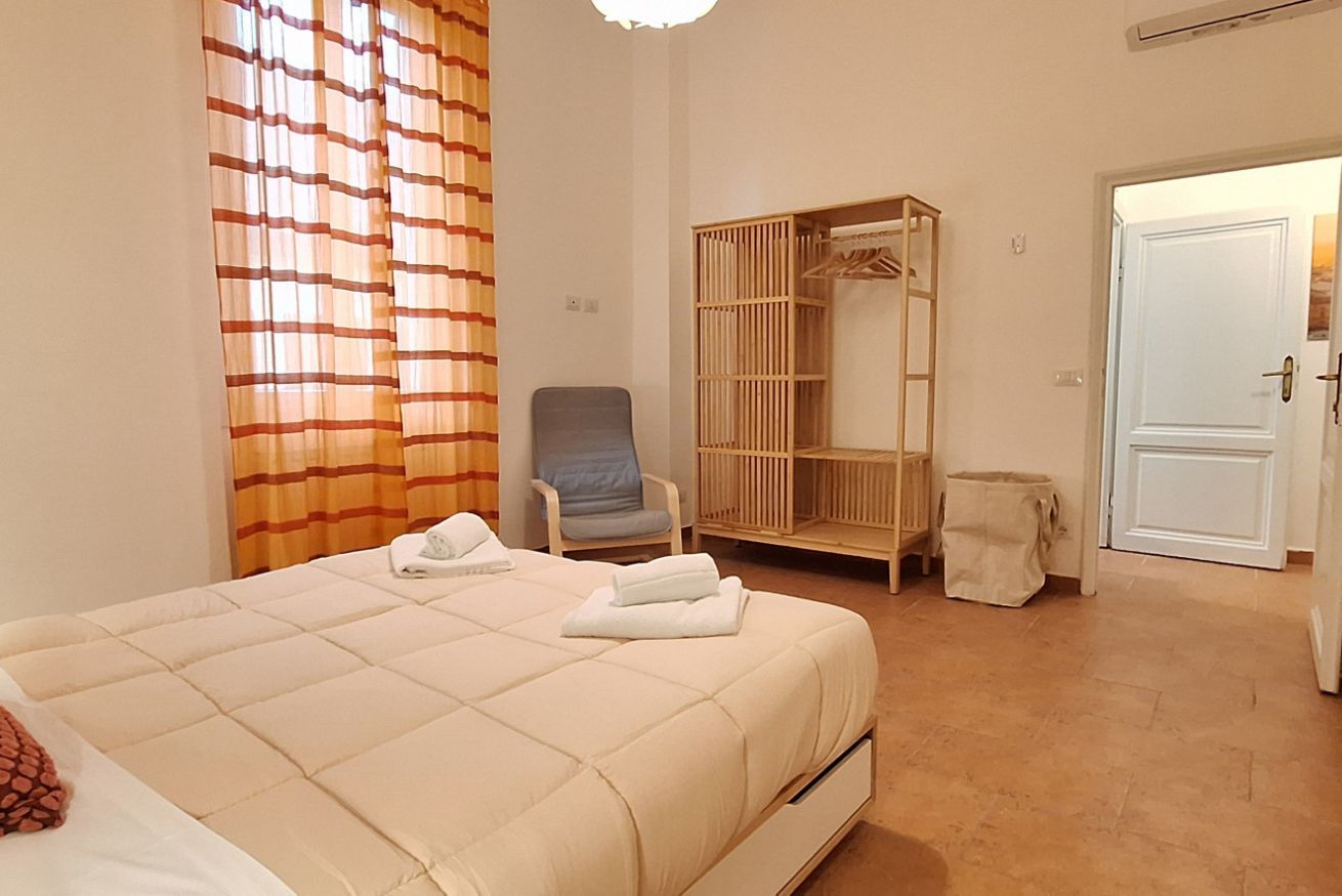 Une chambre à coucher avec un lit, une chaise, une armoire et une porte.