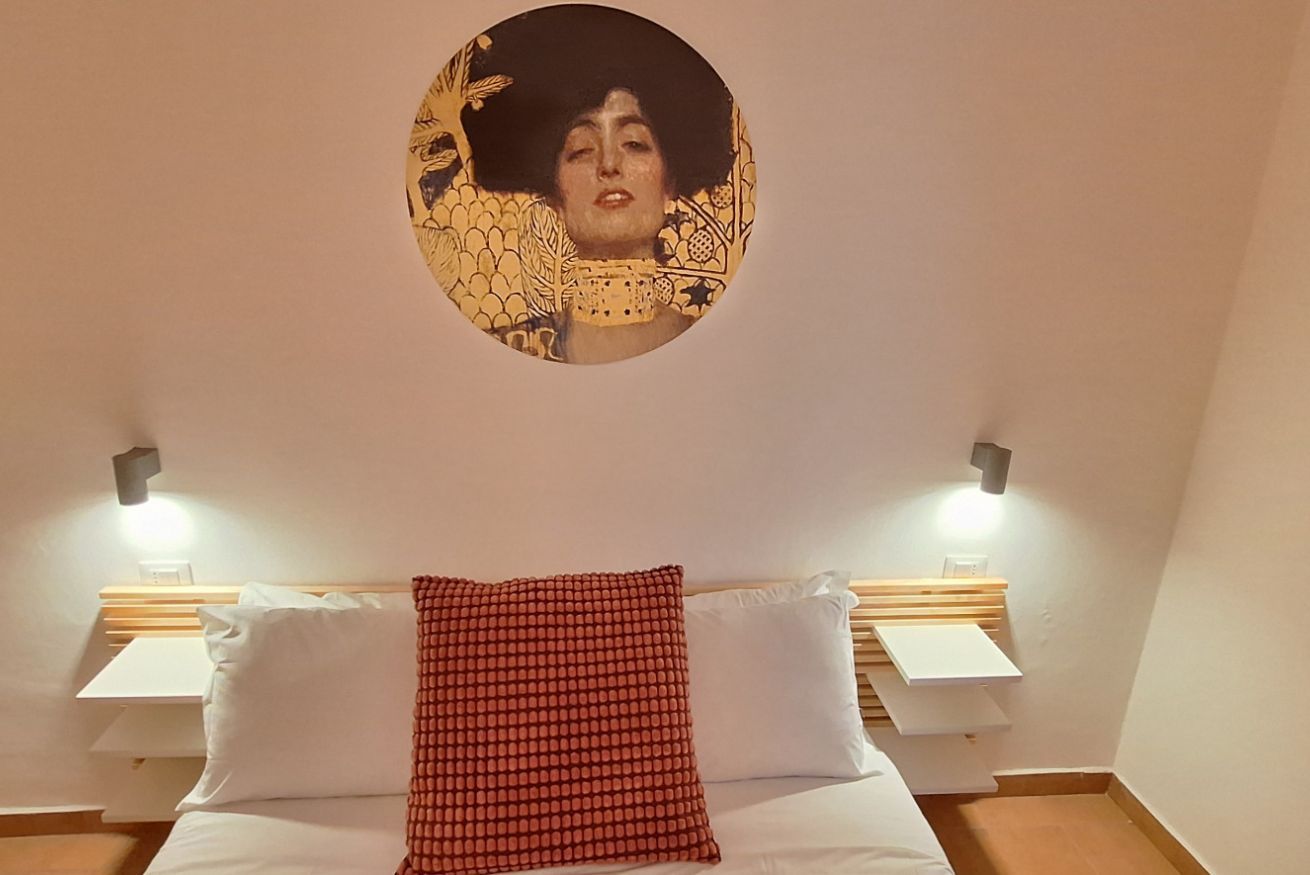 Ein Hotelzimmer mit einem Bett, zwei Nachttischen und einer runden Wanddekoration.