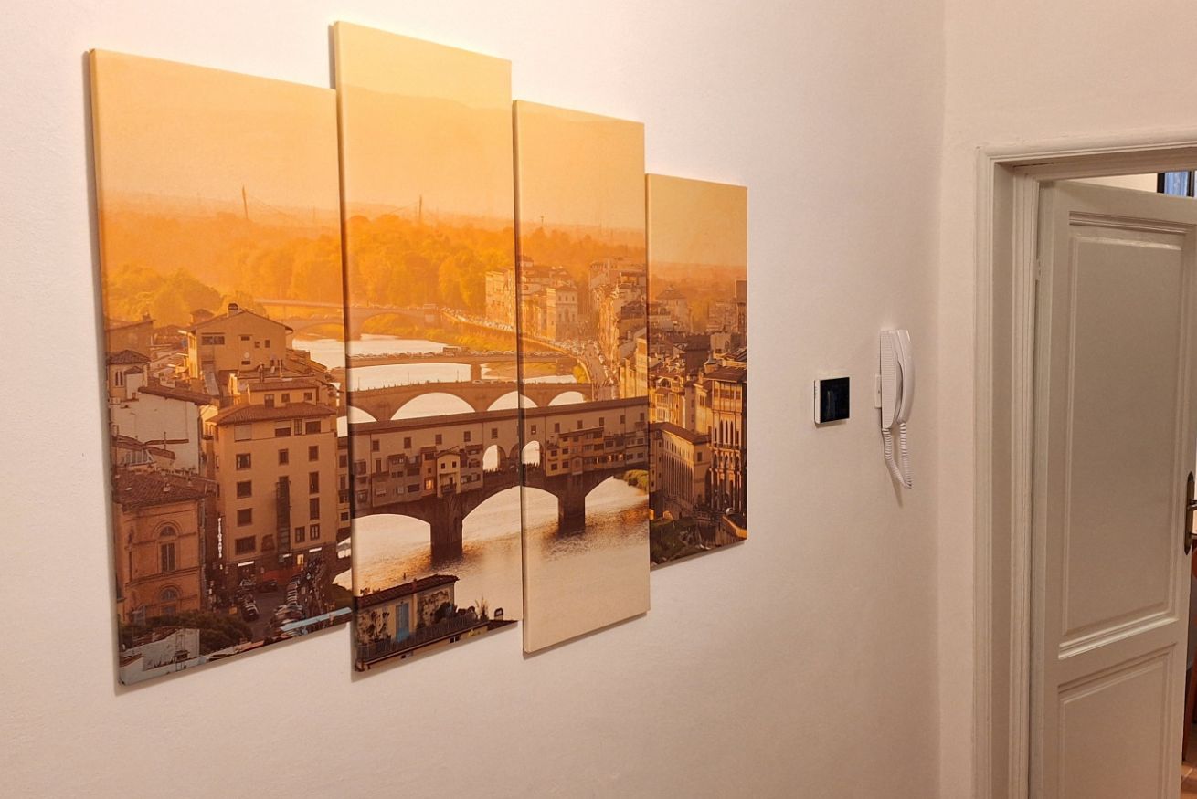A corridor with a wall-mounted artwork depicting a cityscape with a bridge.
