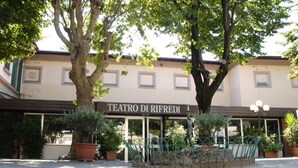 Um edifício com uma placa que diz 'TEATRO DI RIFREDI', indicando um teatro.