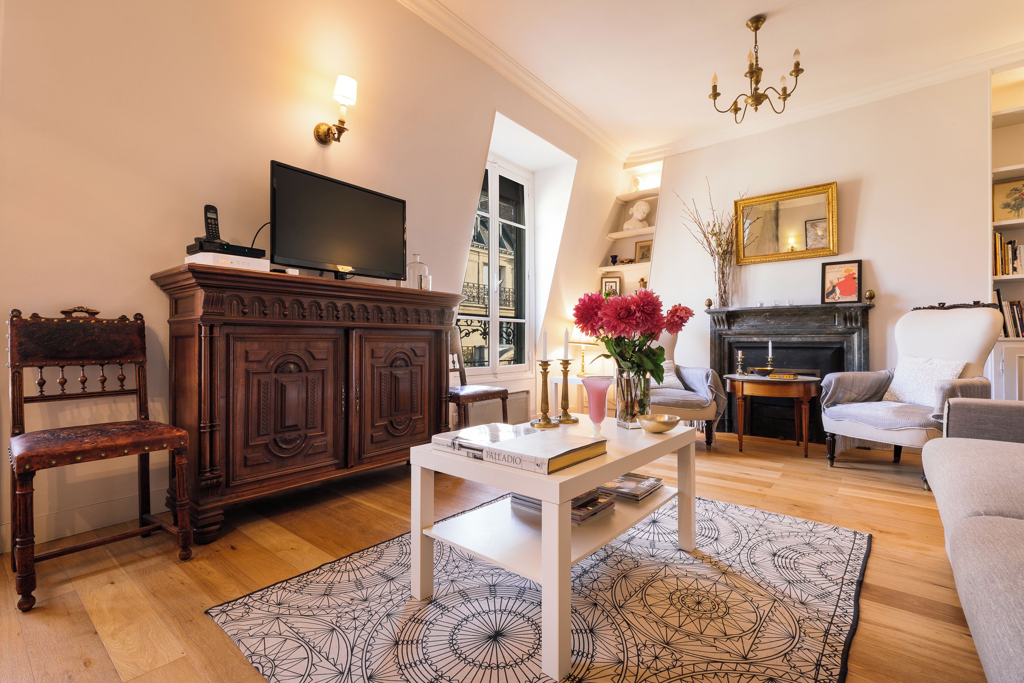 Een woonkamer met een televisie, een open haard, een boekenkast en een eethoek.
