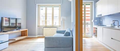 Un apartamento moderno con sala de estar, kitchenette y vistas a través de un ventanal.