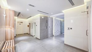 Eine moderne Hotelhalle mit einer Holzbank, einem Empfangstresen und einer Glastrennwand.