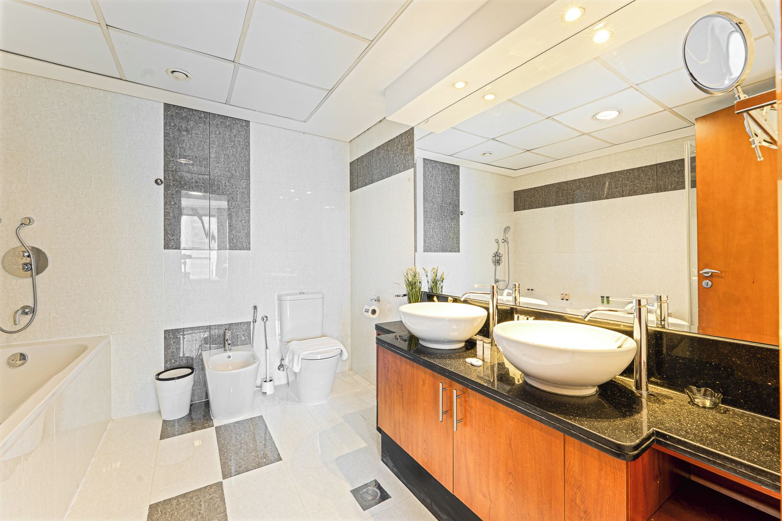 Un baño moderno con dos lavamanos, una bañera y un inodoro.