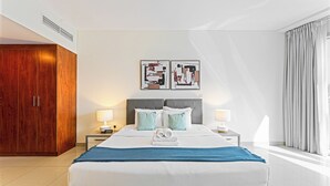 Ein Hotelzimmer mit einem Bett, zwei Nachttischen mit Lampen, einem Kleiderschrank und Bildern an der Wand.