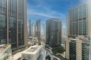 Un perfil urbà modern amb edificis alts, una plaça central amb seients i un cel serè.