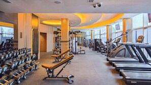 Un gimnàs amb cintes de córrer, halteres i aparells de musculació.