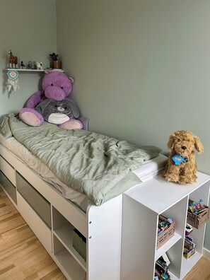 A child's bedroom with a bed, a teddy bear, and a shelf with toys. - Spacious flat by Amager Fælled and the harbour (København)
