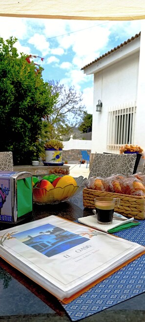 A table with a book, a basket of bread, and a glass of coffee. - El Oasis 🌴 Private Home | Winter Spa & Summer Pool | Near Leana Thermal Baths (MC)