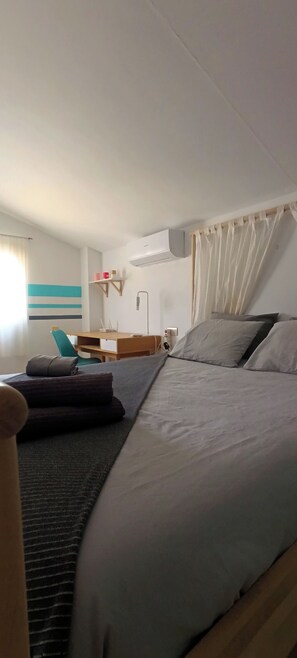 A hotel room with a bed, a desk, a chair, and an air conditioning unit. - El Oasis 🌴 Private Home | Winter Spa & Summer Pool | Near Leana Thermal Baths (MC)