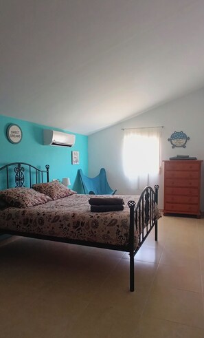 Ein Schlafzimmer mit einem Bett, einer Kommode und einer Wandklimaanlage.