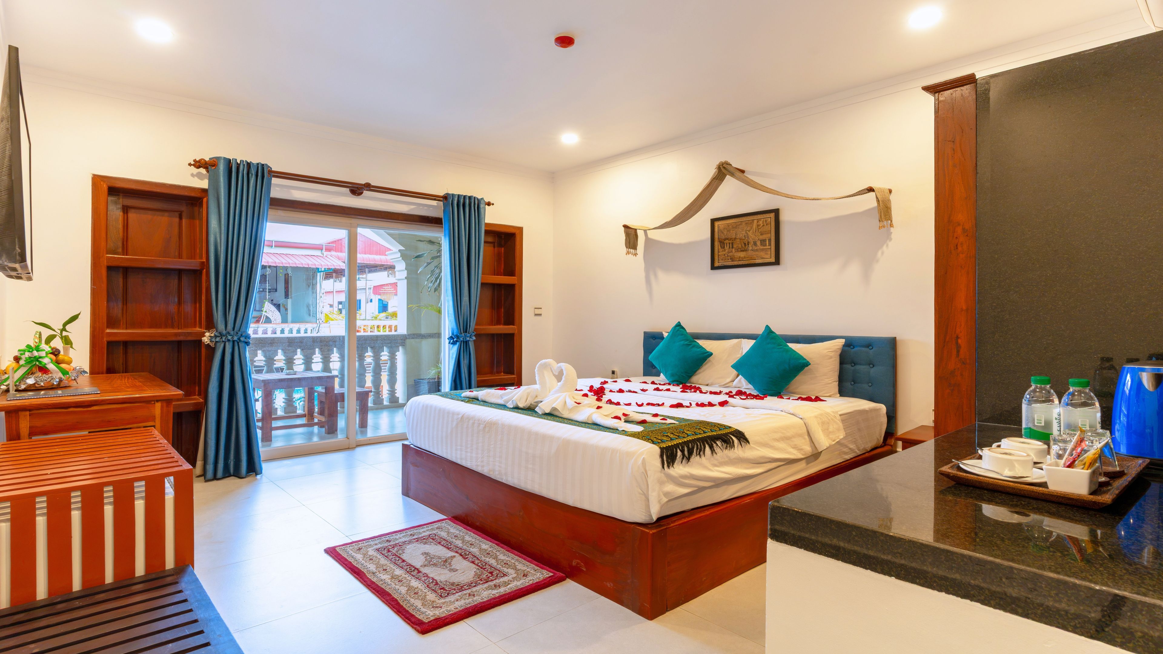 Quarto de hotel com cama, escrivaninha, cadeira, varanda e área de chuveiro.