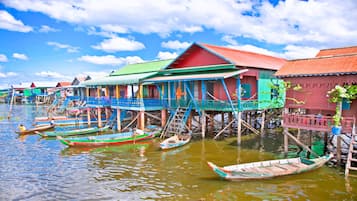 A row of colorful floating houses with boats in the water.