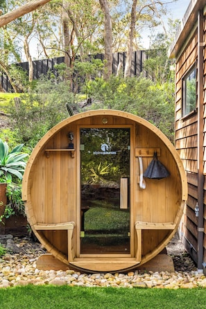 A wooden sauna structure with a door, a bell, and a logo. - The Stillhouse | Sauna, Soak & Pet-Friendly Escape (Rye)