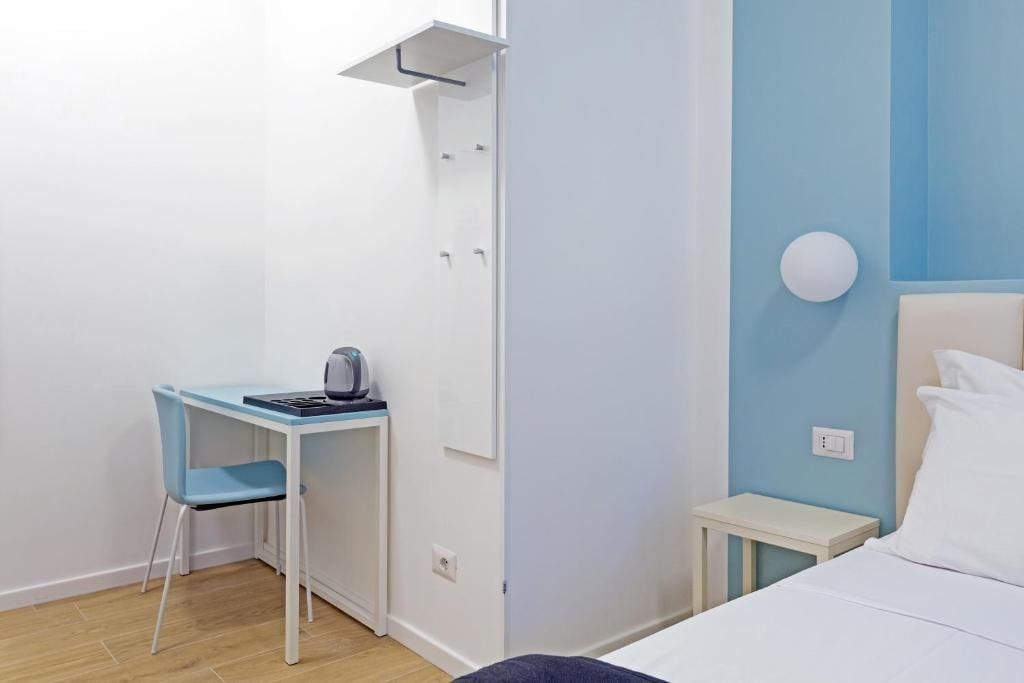 Une petite pièce, bien rangée, comprenant un lit, un bureau avec une chaise et une armoire.