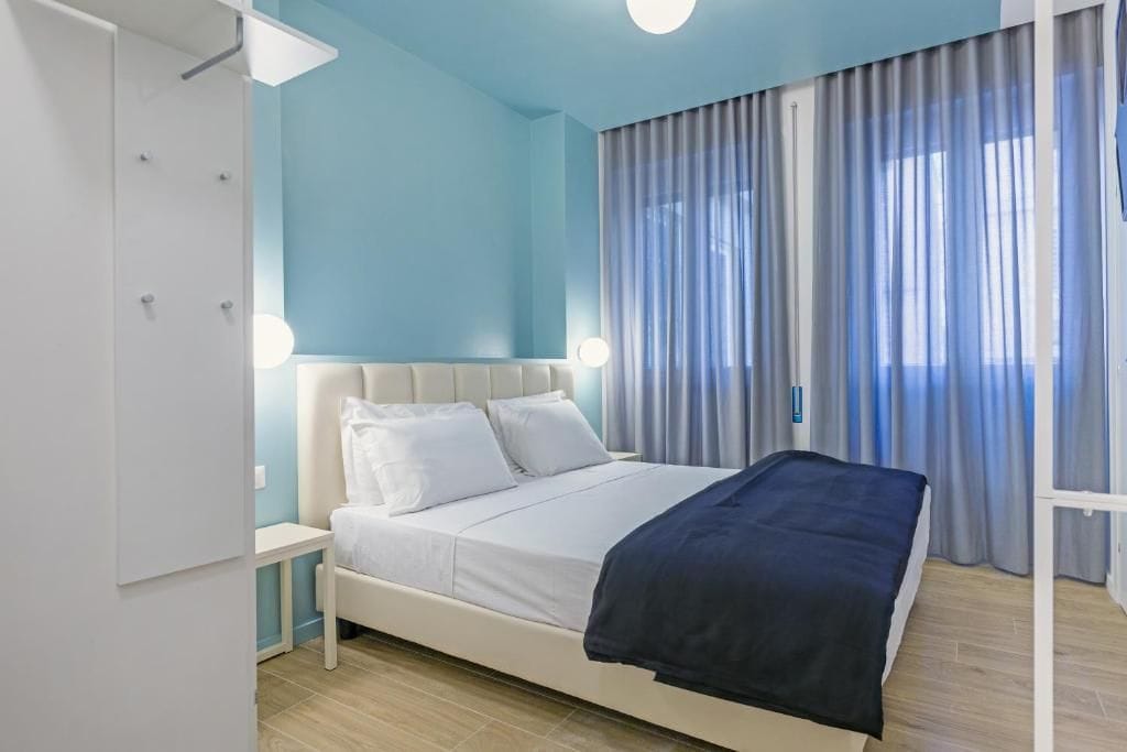 Quarto com cama, guarda-roupa e mesa de cabeceira.