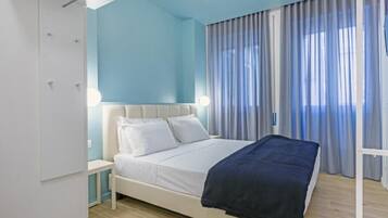 Quarto com cama, guarda-roupa e mesa de cabeceira.