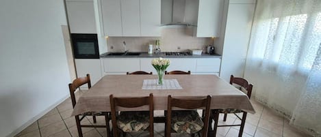 A dining area with a table, chairs, and a vase of flowers.