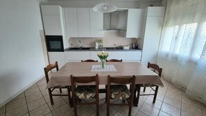 Ein Essbereich mit Tisch, Stühlen und einer Blumenvase.