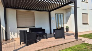 An outdoor patio with a covered seating area, a door, and a sign indicating a restaurant. - Meneghin House Apartment with Wi-Fi and Air Conditioning (San Zenone degli Ezzelini)