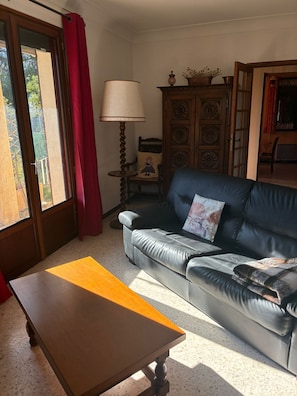 Un salon avec un canapé, une table, une lampe et un meuble.