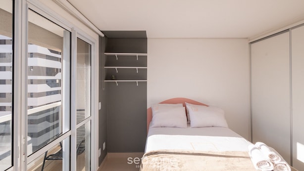 A bedroom with a bed, a wardrobe, and a window. - Studio in a Cond. With Pool, Setor Bueno - Txp1803 (Goiânia)
