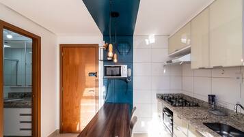 A modern kitchen with a dark wooden table, a built-in microwave, and a gas stove.