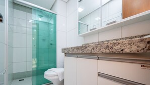 A modern bathroom with a glass shower enclosure, a toilet, and a countertop with a granite-like backsplash. - Studio in a Cond. With Pool, Setor Bueno - Txp1803 (Goiânia)