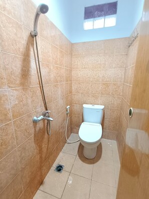 A bathroom with a shower, toilet, and a window. - Banana Homestay Medan (Medan)