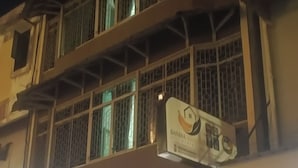 Un edificio de varios pisos con ventanas protegidas por rejas y un cartel que indica un restaurante llamado 'Banna'.