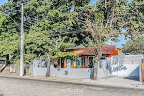 Il s’agit d’une propriété résidentielle dotée d’une entrée sécurisée par un portail, d’un petit garage attenant et d’une maison avec un toit rouge.