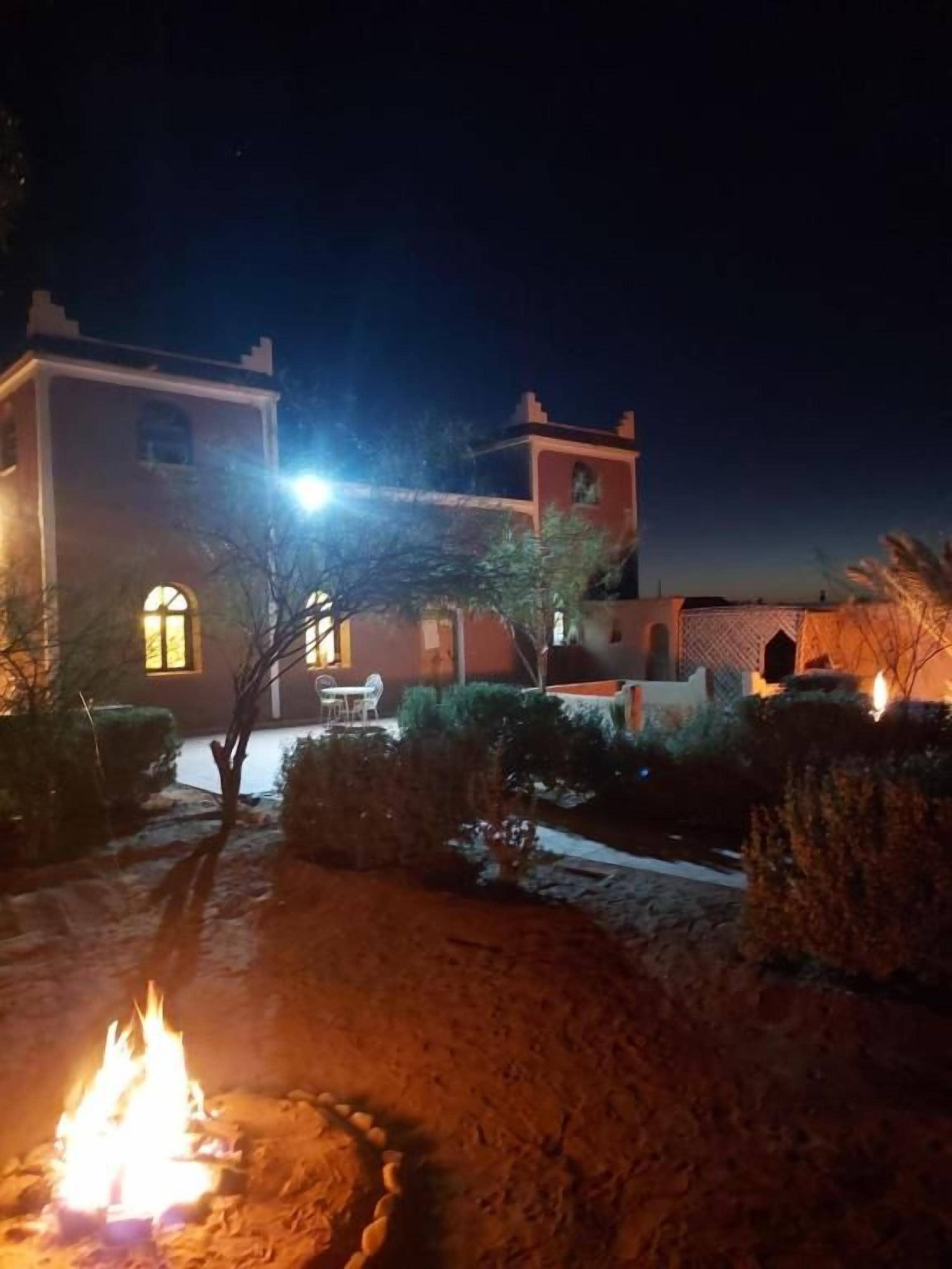 A building with a courtyard, a fire pit, and a well-lit exterior.