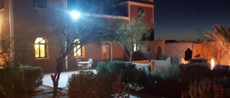 A building with a courtyard, a fire pit, and a well-lit exterior.