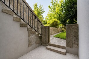 Eine Steintreppe führt zu einer Tür mit einem Metallgeländer.