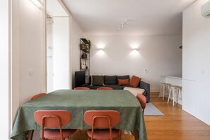 Ein Essbereich mit Tisch und Stühlen, einer Couch und einem Bücherregal.