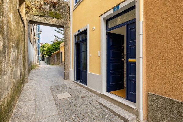 Eine schmale Straße mit einem Gebäude, das eine blaue Tür und eine Hausnummer 2 zeigt.