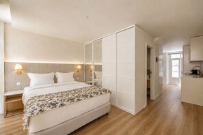 Ein Schlafzimmer mit einem Bett, Nachttischen, einem Kleiderschrank und einer Küchenzeile.