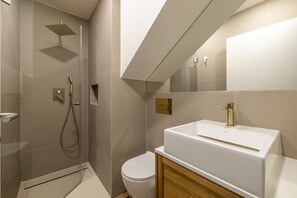 Ein modernes Badezimmer mit Dusche, Toilette und einem großen Waschbecken.